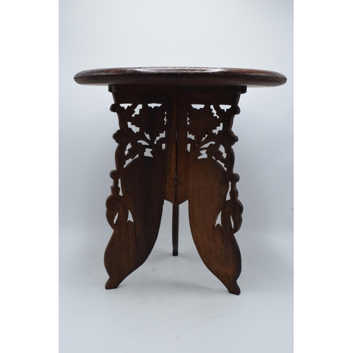 335 - A 20th century Middle Eastern collapsible wooden table with carved and inlaid decoration. 39cm tall.... 