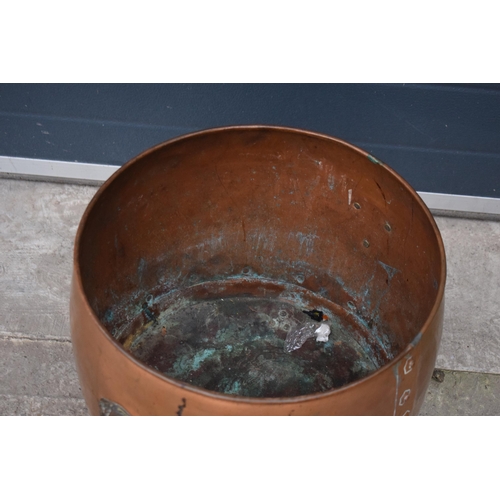 362 - A large early 20th century copper and brass cauldron / log basket with lion's head handles and claw ... 