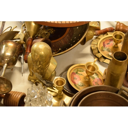 383 - A good collection of brass and copper to include a cow bell, shell cases, a Churchill brass bust, br... 