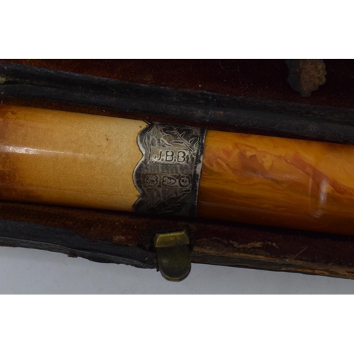 208 - A cased cheroot / cigarette holder with 2 silver collars.