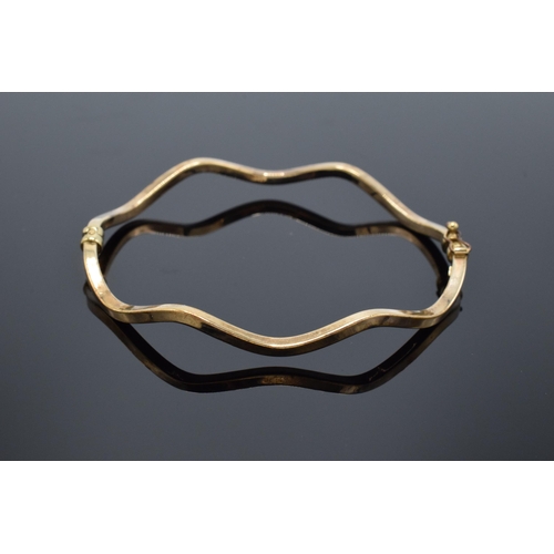 217 - 9ct gold shaped bangle (hollow). 4.1 grams. Hallmarks to inner side. 7cm diameter.