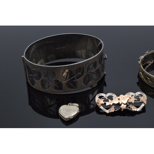 219 - A collection of silver jewellery to include bangles, brooches and a heart-shaped locket together wit... 