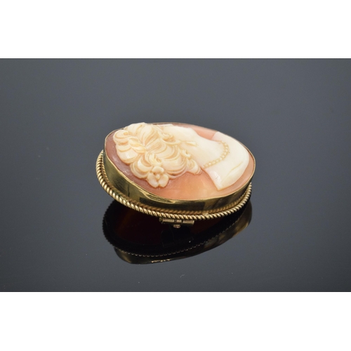 224 - 9ct gold cased cameo pendant / brooch of a lady looking right. 7.0 grams gross weight. 3cm tall.