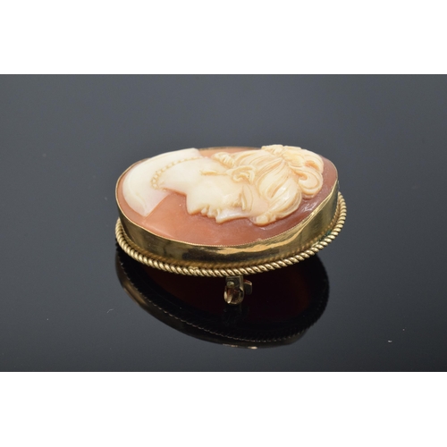 224 - 9ct gold cased cameo pendant / brooch of a lady looking right. 7.0 grams gross weight. 3cm tall.