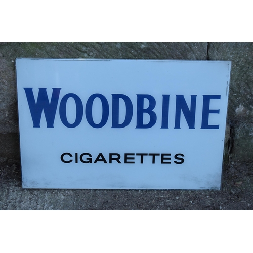 319 - A vintage glass advertising sign of rectangular form for Woodbine Cigarettes. 60 x 40cm. No postage.