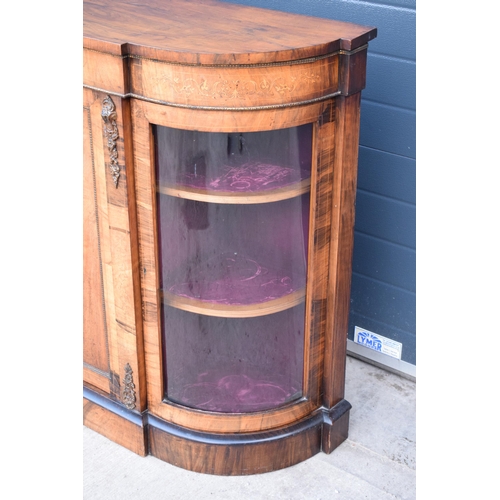 322 - A Victorian walnut breakfront credenza with an inlaid panel door flanked by bow glass doors enclosin... 