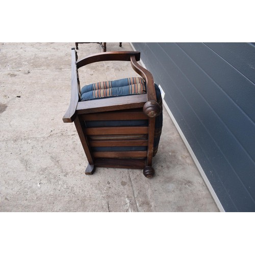 327 - An early 20th century low-seated wooden fireside chair with leather back rest with Coat of Arms or s... 