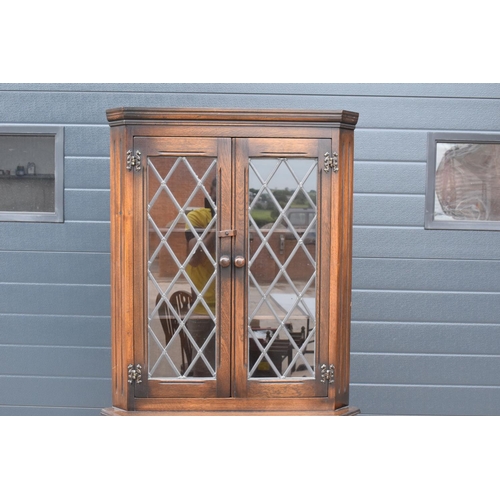 315I - A wooden 20th century Priory style corner display cabinet with glazed upper half. 172cm tall. In goo... 