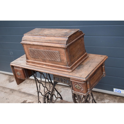 328 - An early 20th century folding Singer sewing machine table. All folds / expands well. Untested. In go... 