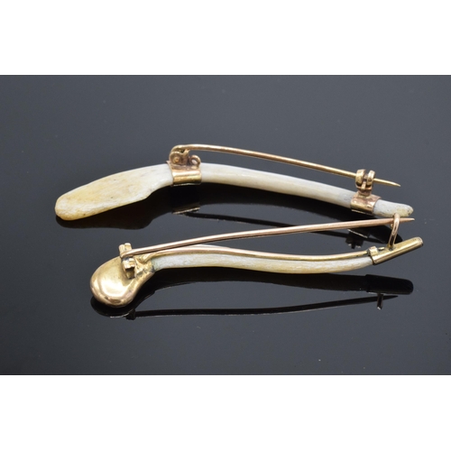 426 - A pair of tiger's clavicle bone brooches set with 9ct gold mounts. Longest 7cm long.