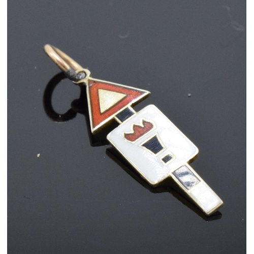 473 - 9ct gold enamelled road sign charm 'Torch of Knowledge'. 2cm long.