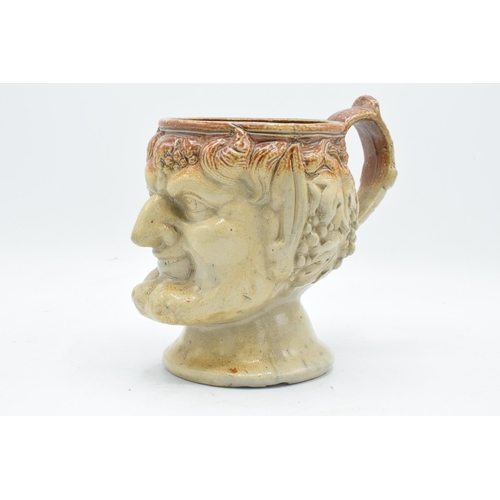 53 - A 19th century stoneware character jug in the form of Bacchus. 19cm tall. Generally in good conditio... 