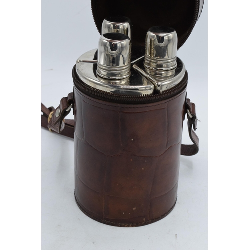 225R - A trio of chrome-plated flasks together in a leather carry case. 18cm tall.