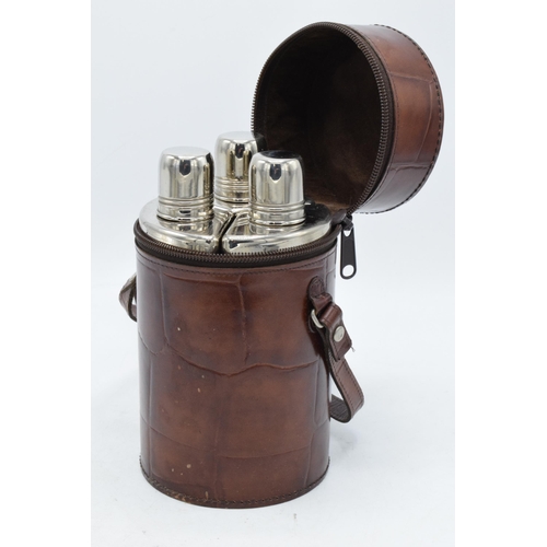 225R - A trio of chrome-plated flasks together in a leather carry case. 18cm tall.