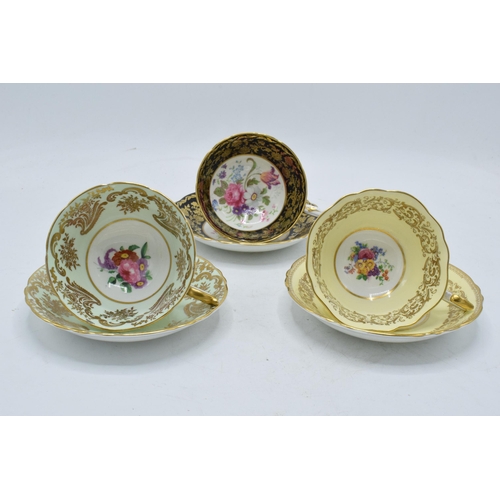 79 - A trio of Paragon Fine Bone China cups and saucers decorated with majestic floral scenes (6 pieces).... 