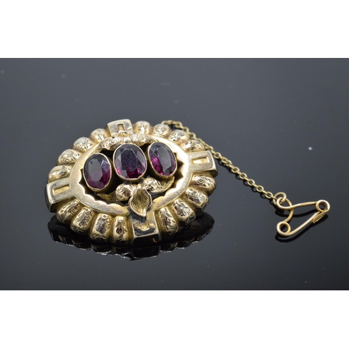 221L - Victorian gold brooch set with 3 large garnets and safety chain. Gross weight 5.6 grams.