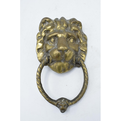 350 - Cast brass door knocker in the form of a lion's head. 21cm long including hoop.