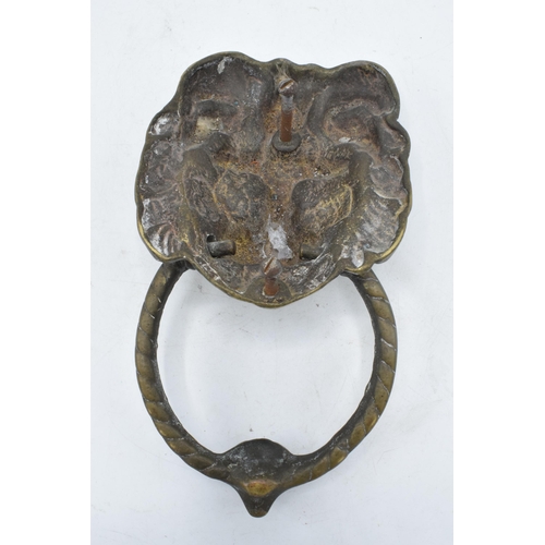 350 - Cast brass door knocker in the form of a lion's head. 21cm long including hoop.