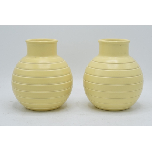 62 - A pair of Wedgwood ribbed vases by Keith Murray in a yellow straw glaze (2). 16cm tall. In good cond... 