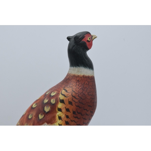 63 - Royal Crown Derby model of a pheasant raised on a ceramic base with raised floral decoration. In goo... 