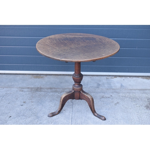 429 - A 19th century oak tilt-top tripod table with circular top on a turned column. 70cm tall, 75cm wide.... 