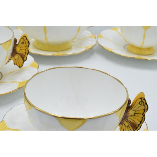 109 - A collection of Aynsley yellow leaf moulded tea ware to include 5 tea cups with butterfly finial han... 
