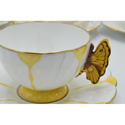 109 - A collection of Aynsley yellow leaf moulded tea ware to include 5 tea cups with butterfly finial han... 