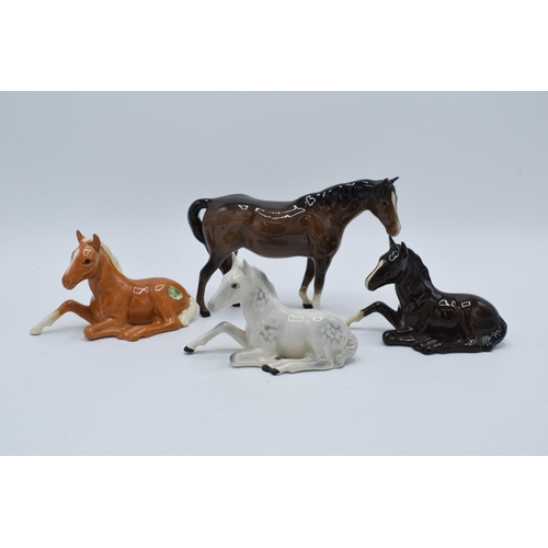 136 - A collection of Beswick horses to include lying foals 915 in grey, brown and palomino colourway toge... 