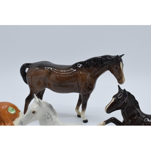 136 - A collection of Beswick horses to include lying foals 915 in grey, brown and palomino colourway toge... 