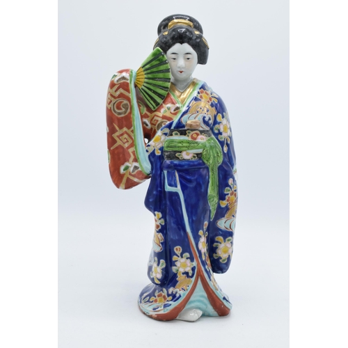 198 - Japanese porcelain Geisha figure in blue floral Kimono holding fan, 31cm high. Early 20th century.