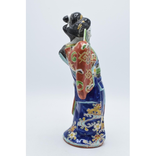 198 - Japanese porcelain Geisha figure in blue floral Kimono holding fan, 31cm high. Early 20th century.