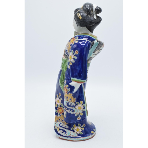 198 - Japanese porcelain Geisha figure in blue floral Kimono holding fan, 31cm high. Early 20th century.