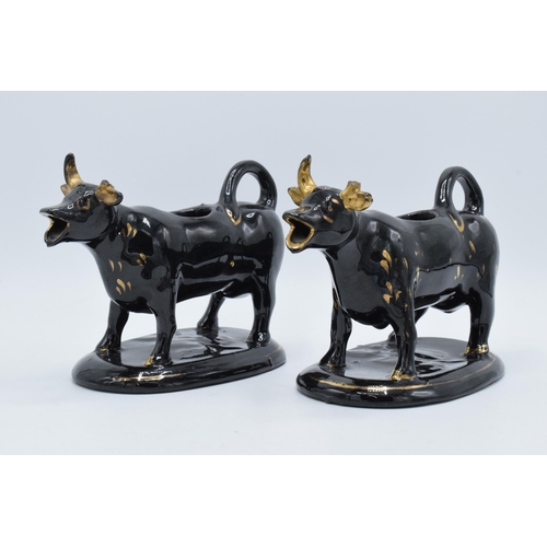 198B - A pair of earthenware 20th century Staffordshire-style cow creamers in Jackfield manner (2) (horns d... 