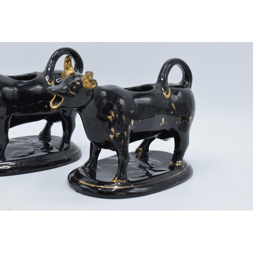 198B - A pair of earthenware 20th century Staffordshire-style cow creamers in Jackfield manner (2) (horns d... 