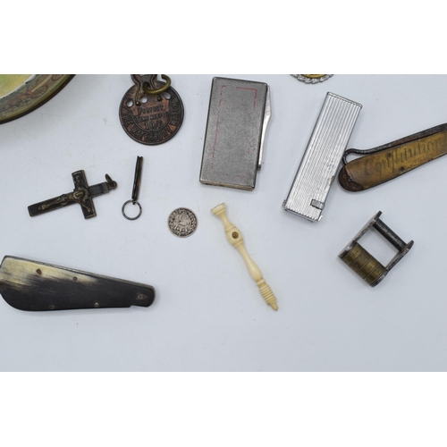 210 - An interesting collection of items to include pen knives,  metal swivel puzzles, lighters, a bone st... 