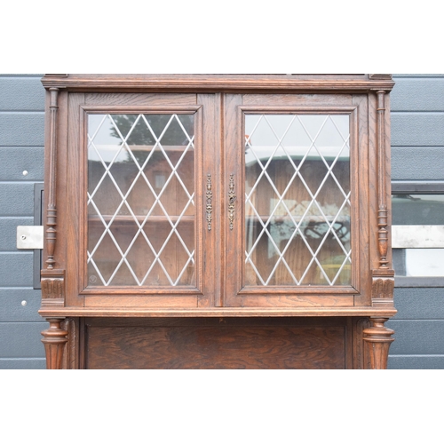 250 - An early 20th century wooden kitchen dresser with glazed upper doors and carved decoration. 218cm ta... 