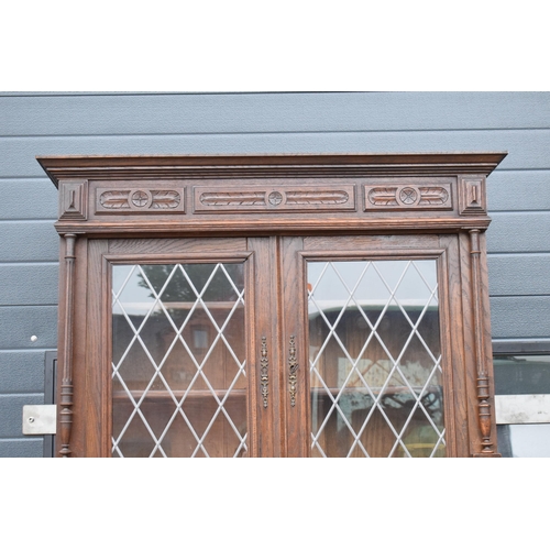 250 - An early 20th century wooden kitchen dresser with glazed upper doors and carved decoration. 218cm ta... 