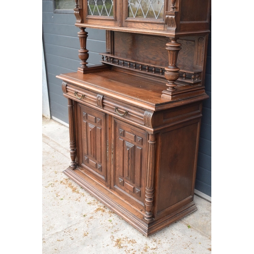 250 - An early 20th century wooden kitchen dresser with glazed upper doors and carved decoration. 218cm ta... 