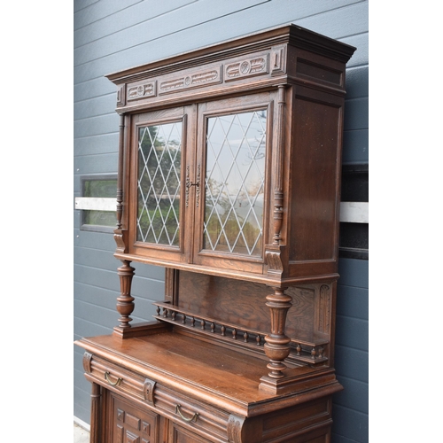 250 - An early 20th century wooden kitchen dresser with glazed upper doors and carved decoration. 218cm ta... 