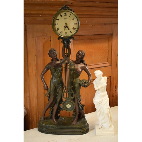 257 - A contemporary Julianna Studios swinging mantle clock in the form of 2 ladies in robes holding it to... 