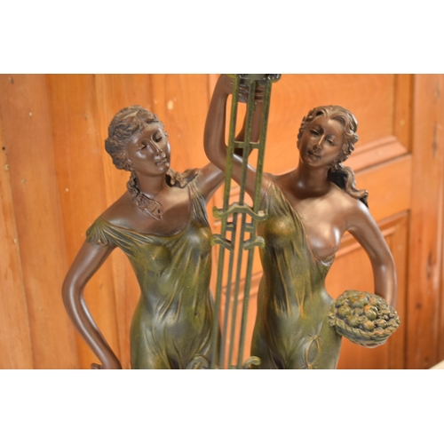 257 - A contemporary Julianna Studios swinging mantle clock in the form of 2 ladies in robes holding it to... 