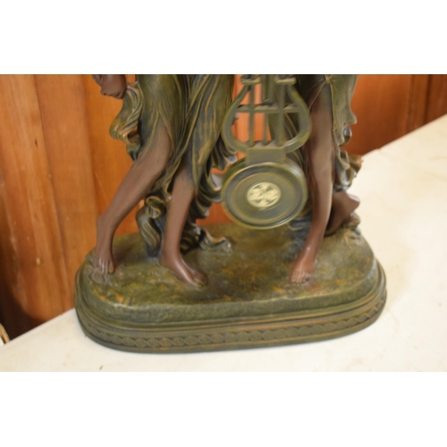 257 - A contemporary Julianna Studios swinging mantle clock in the form of 2 ladies in robes holding it to... 