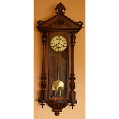 269 - A late 19th century ornate Vienna wall clock with pendulum and weights. 128cm tall.