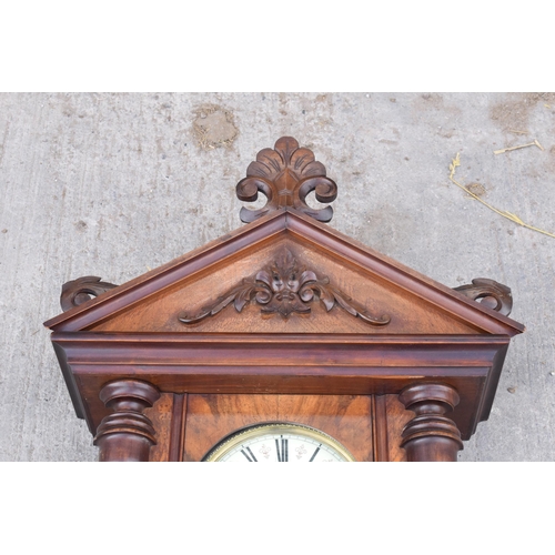 269 - A late 19th century ornate Vienna wall clock with pendulum and weights. 128cm tall.