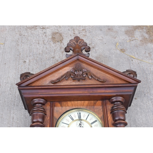 269 - A late 19th century ornate Vienna wall clock with pendulum and weights. 128cm tall.