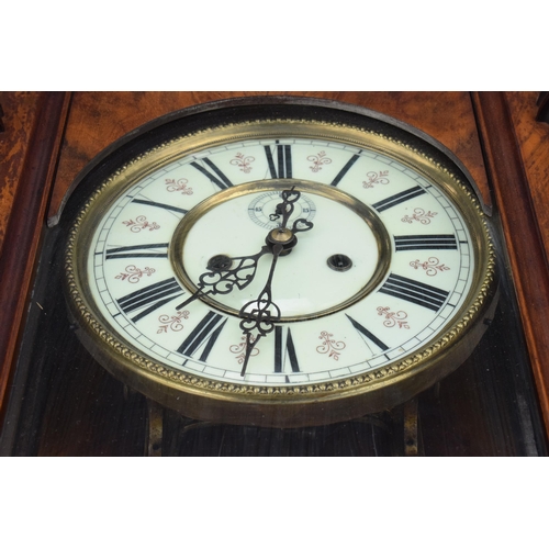 269 - A late 19th century ornate Vienna wall clock with pendulum and weights. 128cm tall.