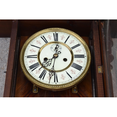 269 - A late 19th century ornate Vienna wall clock with pendulum and weights. 128cm tall.