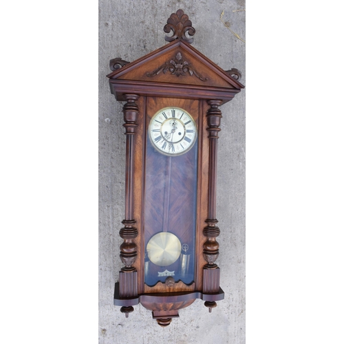 269 - A late 19th century ornate Vienna wall clock with pendulum and weights. 128cm tall.