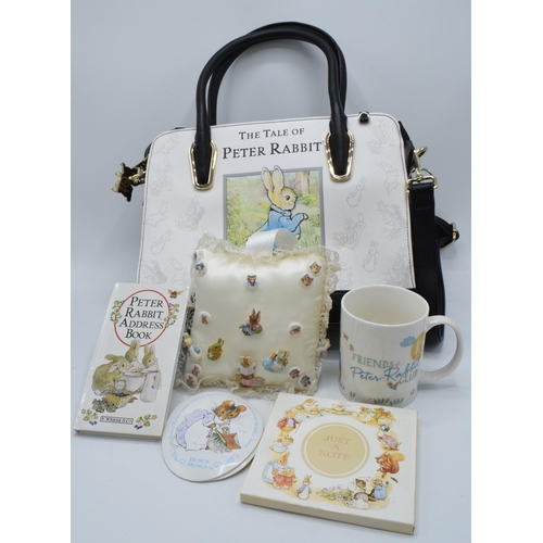 285 - A collection of Beatrix Potter collectables to include a Peter Rabbit handbag, cushion with pin badg... 