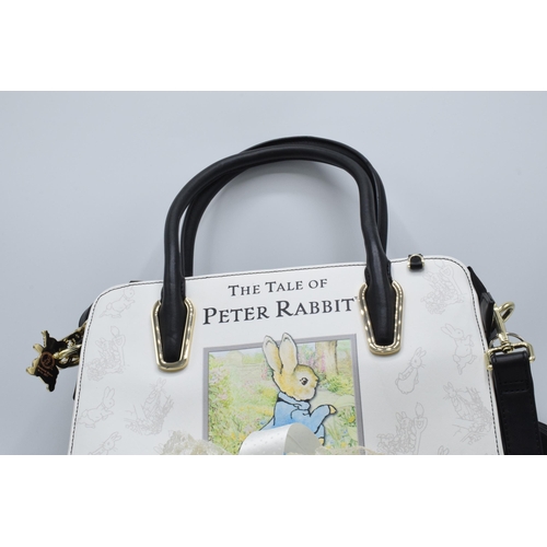 285 - A collection of Beatrix Potter collectables to include a Peter Rabbit handbag, cushion with pin badg... 